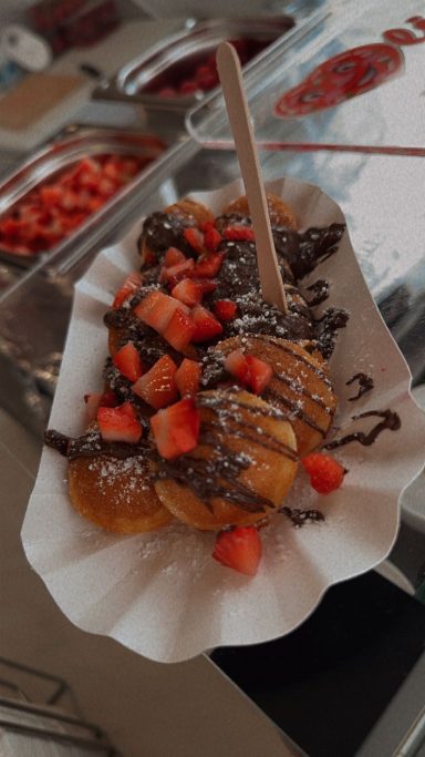 Köstliche Waffel mit Schokolade und frischen Erdbeeren auf einem Papierboot.