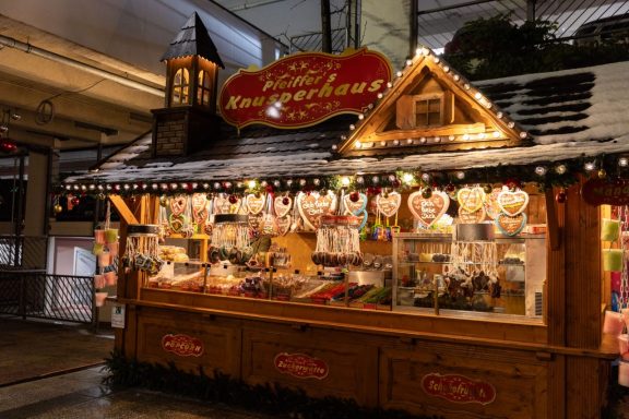 Weihnachtsmarktstand mit Süßigkeiten und festlicher Dekoration.